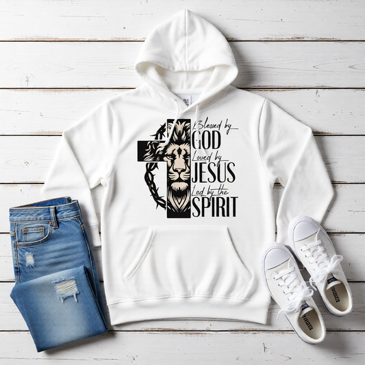 White hoodie with a graphic design on a wooden surface, accompanied by jeans and sneakers.